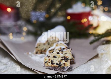 Stollen di Natale, Christstollen - pane classico del lievito. Tradizione natalizia con sfondo bokeh. Sfondo festivo. Foto Stock