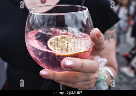 Colonia, Germania 31 luglio 2022: Una giovane donna che tiene un bicchiere di pampelle rosso rubino in una festa di strada a colonia rheinauhafen Foto Stock