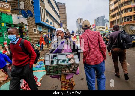 Nairobi, Kenya. 2nd ago 2022. I pedoni passano accanto ai falchi che vendono i loro prodotti per le strade del quartiere centrale degli affari di Nairobi in Kenya. La maggior parte delle scuole keniote erano state chiuse il 2 agosto 2022 per una breve vacanza di medio periodo in seguito ad un ordine del professore del Segretario del Gabinetto dell'Istruzione (CS) George Magoha di creare abbastanza tempo di preparazione per le elezioni generali del 9 agosto 2022 in Kenya. (Credit Image: © Donwilson Odhiambo/ZUMA Press Wire) Foto Stock