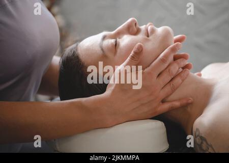 massaggio viso con olio in stile tradizionale realizzato da donne di bellezza professionisti. massaggio anti-età Foto Stock