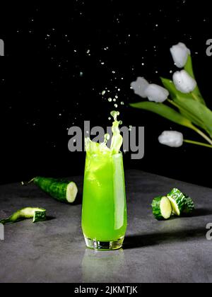 Un colpo verticale del succo di cetriolo e fiori Foto Stock