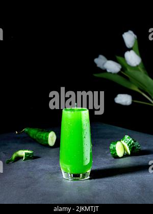 Un colpo verticale del succo di cetriolo e fiori Foto Stock