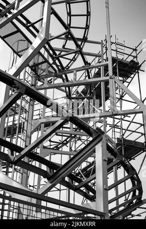 Una foto in scala di grigi delle rotaie delle montagne russe sul Brighton Pier. Regno Unito. Foto Stock