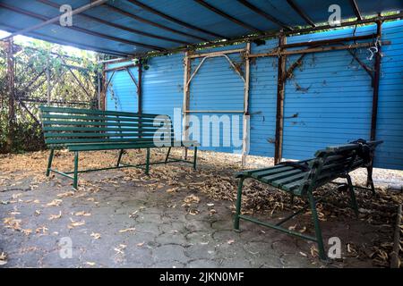 Gazebo realizzato localmente con panchine e foglie a terra Foto Stock