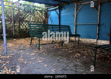 Gazebo realizzato localmente con panchine e foglie a terra Foto Stock