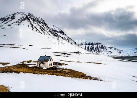 Una casa abbandonata circondata da montagne in Islanda Foto Stock