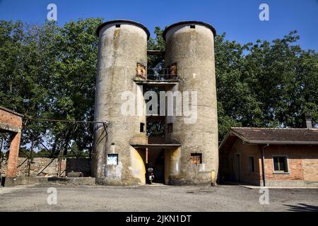 Vecchi silos in un cortile vicino a edifici usurati Foto Stock