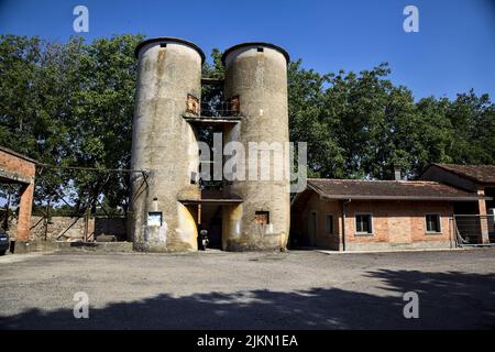 Vecchi silos in un cortile vicino a edifici usurati Foto Stock