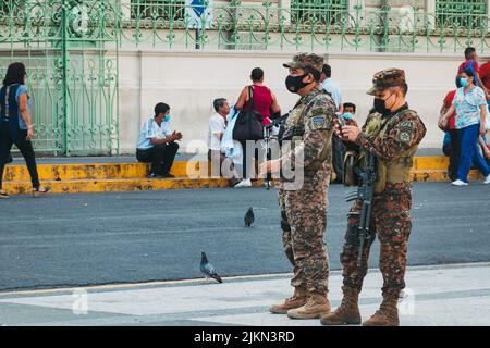 Comandamenti dell'esercito Salvadoran di fronte al Palazzo Nazionale di El Salvador, dopo che uno stato di emergenza è stato dichiarato a causa della violenza di banda di livello record Foto Stock