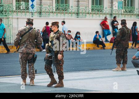 Comandamenti dell'esercito Salvadoran di fronte al Palazzo Nazionale di El Salvador, dopo che uno stato di emergenza è stato dichiarato a causa della violenza di banda di livello record Foto Stock