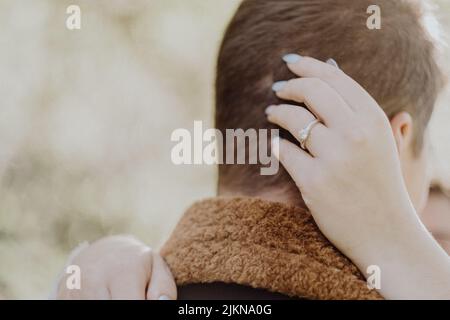 Un primo piano delle mani della donna che abbraccia il marito Foto Stock