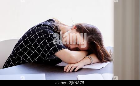 Male chiudi gli occhi per un po'. Una giovane donna d'affari che prende un pisolino nel suo ufficio. Foto Stock
