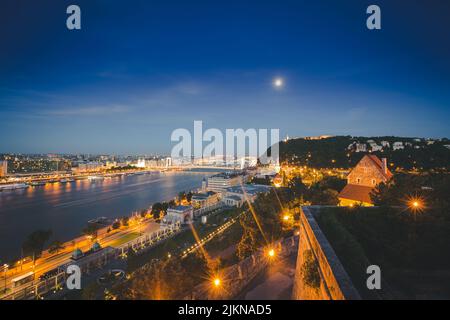 Una vista notturna del Danubio a Budapest con il Ponte Elisabetta visto da lontano Foto Stock