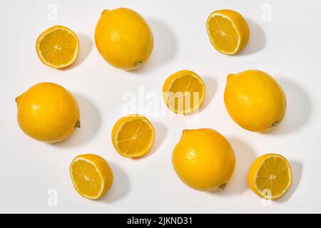 Vista dall'alto del limone con metà e limoni interi maturi su sfondo bianco Foto Stock