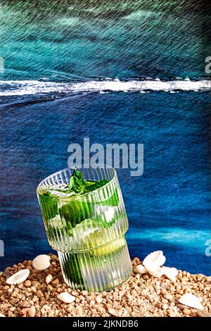 Uno scatto verticale di un bicchiere di cocktail alcolico con calce su una spiaggia di ciottoli con fondo marino Foto Stock