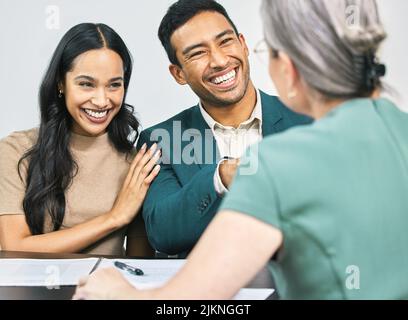 Ottenere le loro finanze in ordine. Una coppia giovane che va sopra un certo lavoro di ufficio durante un incontro con il loro consulente finanziario. Foto Stock