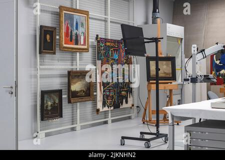 Opere d'arte in mostra presso l'atelier laboratorio di restauro in attesa di trattamento nel museo del deposito d'arte Boijmans van Beuningen con panca di lavoro in primo piano Foto Stock