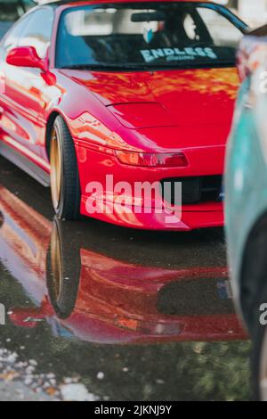 Uno scatto verticale di una Toyota MR2 rossa da 1990 parcheggiata in strada Foto Stock