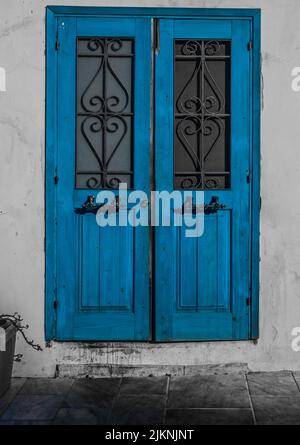 Un effetto spruzzi verticale bianco e nero di una vecchia porta d'epoca di colore blu Foto Stock