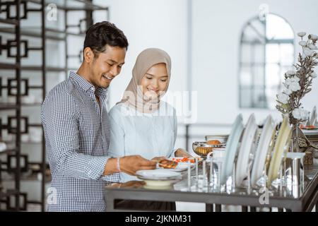 Giovane coppia asiatica che cerca di scegliere piatti in ceramica Foto Stock