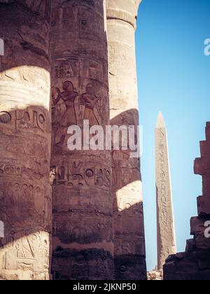 Uno scatto verticale delle antiche colonne con sculture egiziane nel tempio di Karnak, Luxor Foto Stock