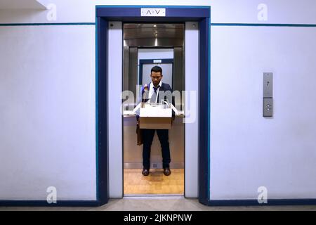 Scendendo. Sparo a tutta lunghezza di un bel giovane uomo d'affari che si guarda depresso dopo essere stato trench dal lavoro. Foto Stock