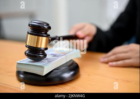 Un giudice gavel è su una borra di banconote o una borra di dollari americani. Concetto di corruzione. Immagine close-up Foto Stock