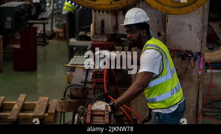 Heavy Industry Foreman Engineer ware giubbotto di sicurezza manutenzione preventiva giornaliera macchina di controllo in fabbrica di produzione, utilizzare appunti, hanno discussione Foto Stock