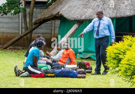 Un primo piano di una guardia di sicurezza maschile che addestra giovani maschi ad Harare, Zimbabwe Foto Stock