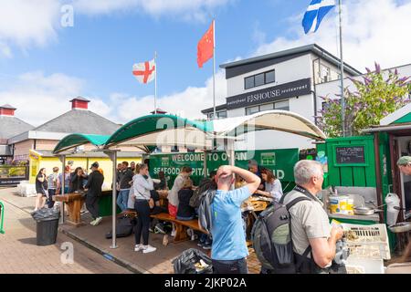 Oban resort città e banchina, capanna verde che vende pesce fresco e crostacei ai clienti, Oban, Argyll, Scozia in sole estate giorno 2022 Foto Stock