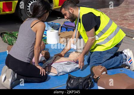 Scena di un incidente con gli studenti di medicina che mostrano le istruzioni di pronto soccorso Foto Stock