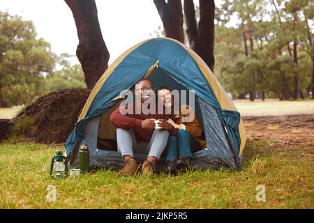 Ovunque mi senta come a casa con te al mio fianco. Una giovane coppia beve caffè mentre si siede nella loro tenda. Foto Stock