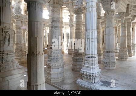Un primo piano di file di colonne scolpite intricate nel tempio Ranakpur Jain in India Foto Stock