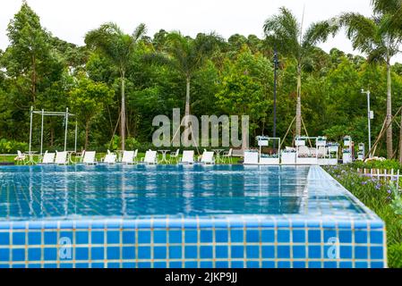 Piscina infinity e sedie a sdraio in un hotel di lusso Foto Stock