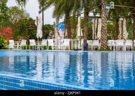 Piscina infinity e sedie a sdraio in un hotel di lusso Foto Stock