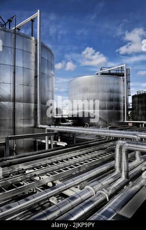 Un primo piano di tubi e serbatoi per la lavorazione del petrolio greggio Foto Stock