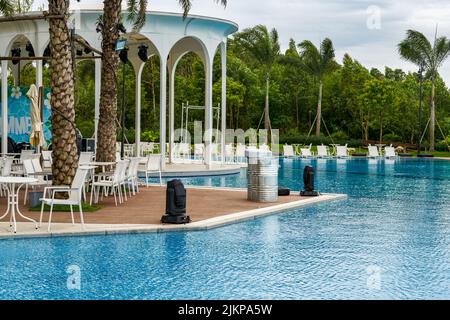 Piscina infinity e sedie a sdraio in un hotel di lusso Foto Stock