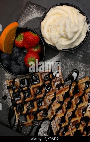 Una vista dall'alto dei waffle belgi con gelato allo sciroppo d'acero e frutti di bosco Foto Stock
