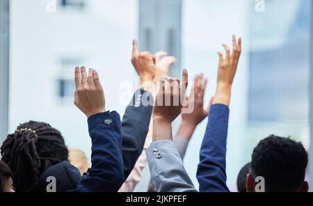 Se credi, un gruppo di membri del personale con le braccia alzate. Foto Stock