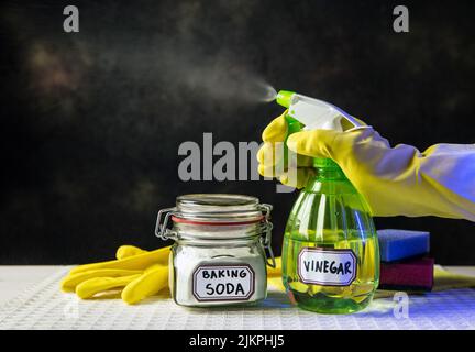 Uso di bicarbonato di sodio e aceto bianco per la pulizia domestica. Aceto bianco in bottiglia spray e bicarbonato di sodio in vaso di vetro. Foto Stock