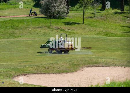 Una squadra di manutenzione con un trattore al campo da golf Jamor di Lisbona Foto Stock