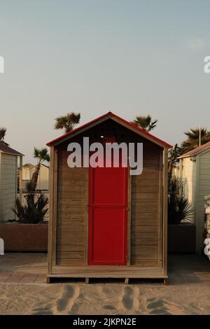 Una foto verticale di un piccolo cottage in legno sulla spiaggia Foto Stock