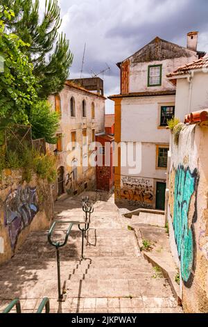 Scale con ringhiere e pareti con arte di strada nelle strette stradine della storica città di Coimbra in Portogallo Foto Stock