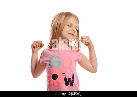 Primo piano ritratto di un bel ragazzo biondo in una t-shirt rosa in posa isolata su sfondo bianco. Foto Stock