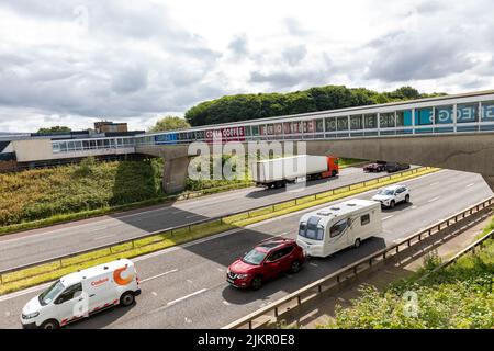 Traffico sull'autostrada M6 accanto a Lancaster servizi nel Nord dell'Inghilterra, auto trainante caravan in direzione nord, Lancaster, Inghilterra, Regno Unito Foto Stock