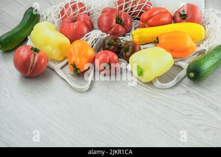 Set di pomodori da agricoltura, peperoni, zucchine in sacchetto di cotone. Shopping senza rifiuti. Stile rurale. Foto Stock