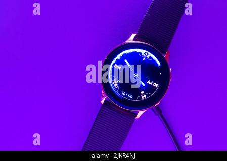 Telefono cellulare e smartwatch con caricabatterie wireless su tavolo in  legno. Moderno accessorio per il luogo di lavoro Foto stock - Alamy