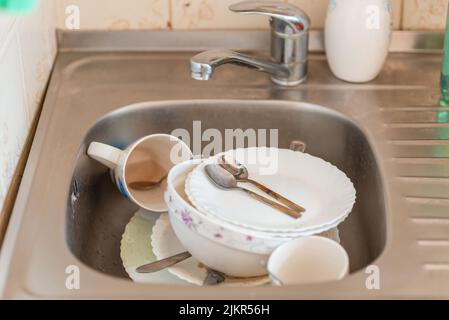 un sacco di piatti sporchi e un po' di confusione nel lavandino da cucina  Foto stock - Alamy