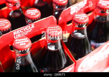 Bottiglie di coke con Coca-Cola che spinge a riciclare, bottiglie, tappi e contenitori di cartone Foto Stock