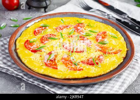 Omelette con pomodori, erbe e formaggio grattugiato. Colazione facile Foto Stock